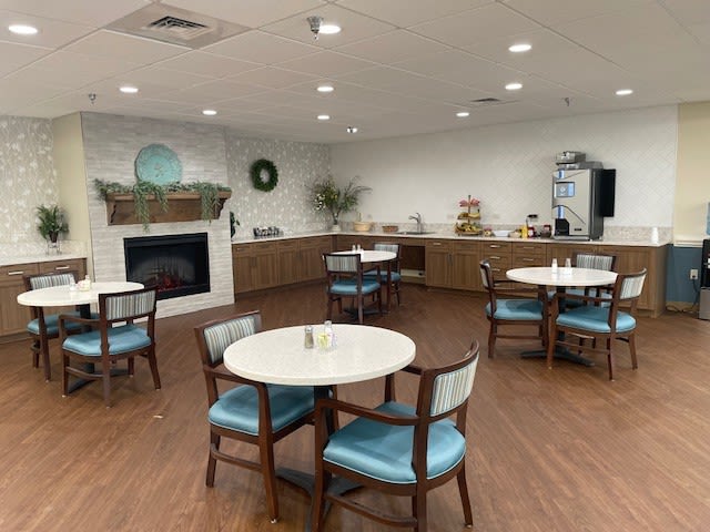 Cozy community dining area with fireplace and kitchenette