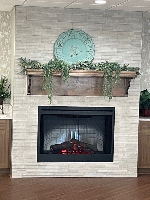 Modern fireplace with wooden mantel and greenery decor