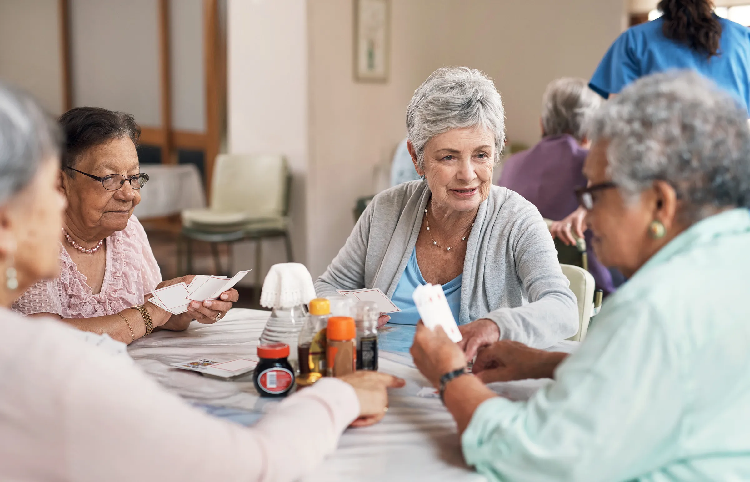 Seniors playing cards together at community center table